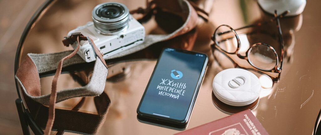a table topped with a camera and a cell phone