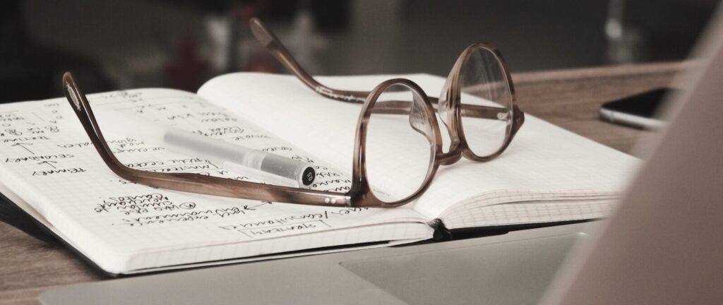 eyeglasses with gray frames on the top of notebook