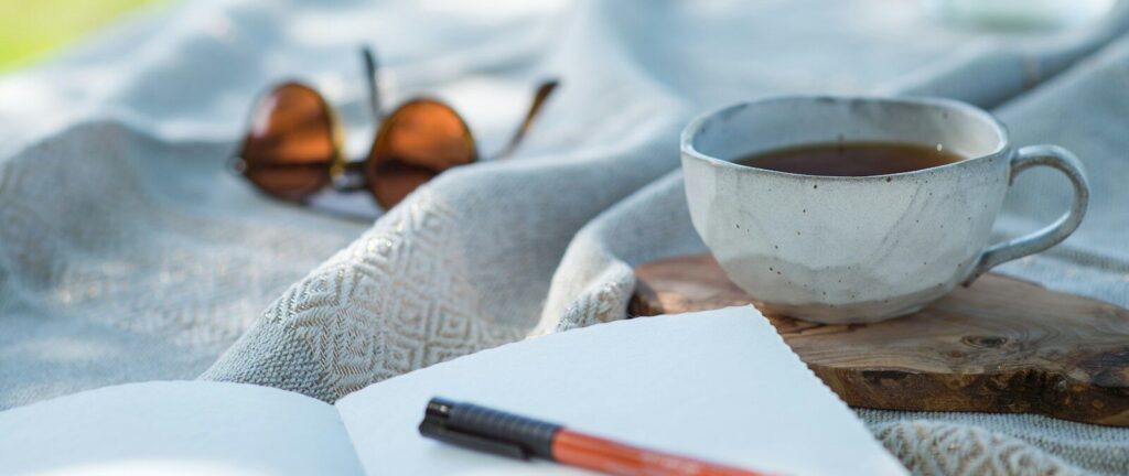 white ceramic cup on white textile