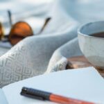 white ceramic cup on white textile