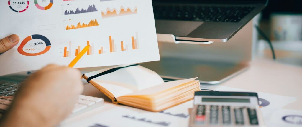 a person holding a piece of paper over a laptop