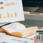 a person holding a piece of paper over a laptop