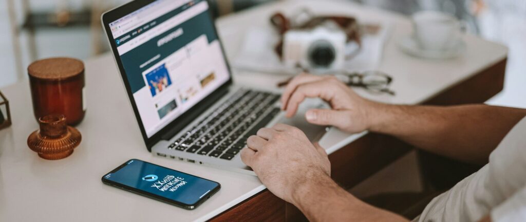 a man sitting at a desk using a laptop computer