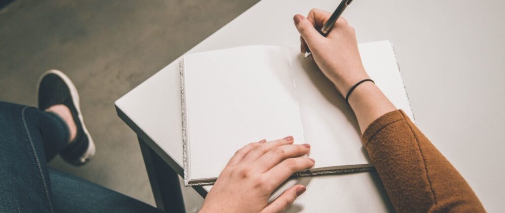 person writing on white paper