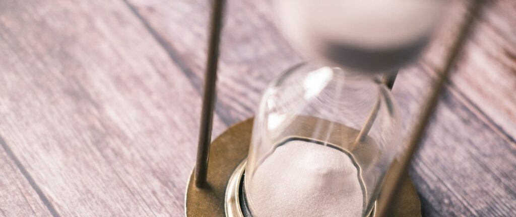 an hourglass sitting on top of a wooden table