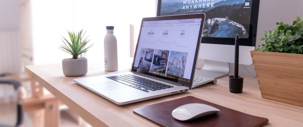 MacBook Pro on table beside white iMac and Magic Mouse