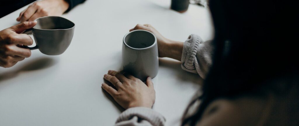 woman in black long sleeve shirt holding black ceramic mug