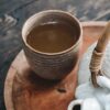 white and brown ceramic teapot on wooden tray
