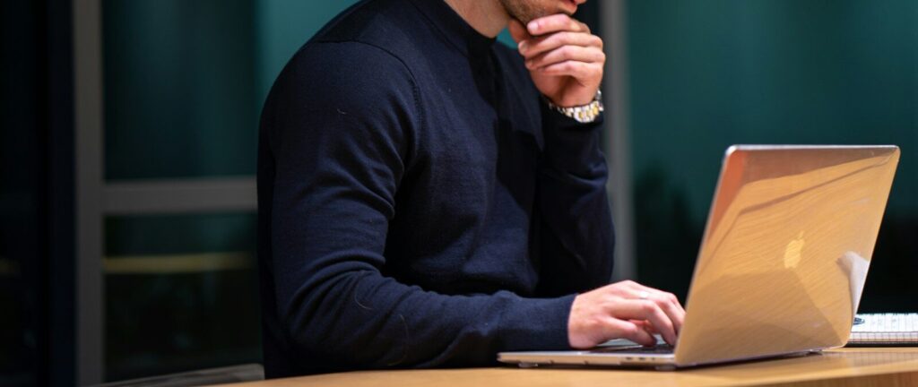man in black long sleeve shirt sitting in front of macbook