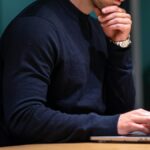 man in black long sleeve shirt sitting in front of macbook