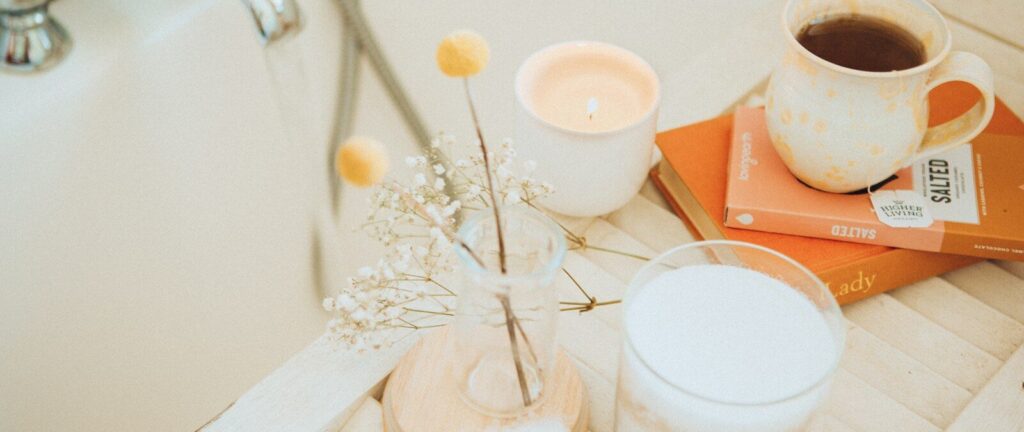 a cup of coffee and some books on a bathtub