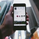 high angle photo of person holding turned on smartphone with tall buildings background