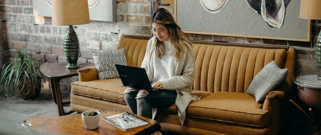 woman using laptop while sitting on chair