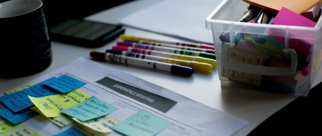 sticky notes on paper document beside pens and box