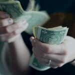 focus photography of person counting dollar banknotes