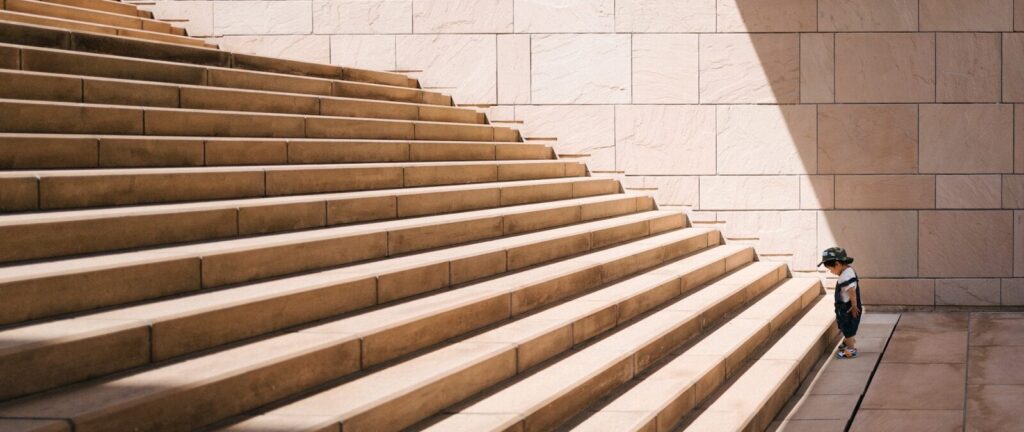 toddler's standing in front of beige concrete stair