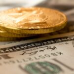 three round gold-colored coins on 100 US dollar banknotes