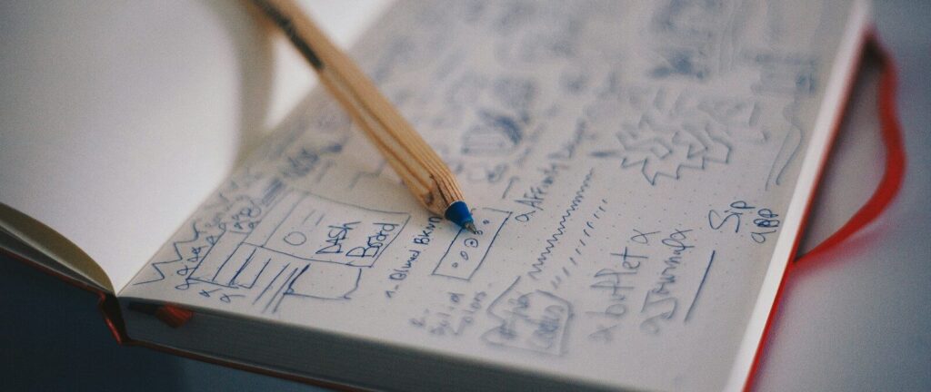 blue ballpoint pen on white notebook