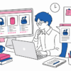 PC上で複数の商品写真やスペックを見比べながら、記事を書いている会社員